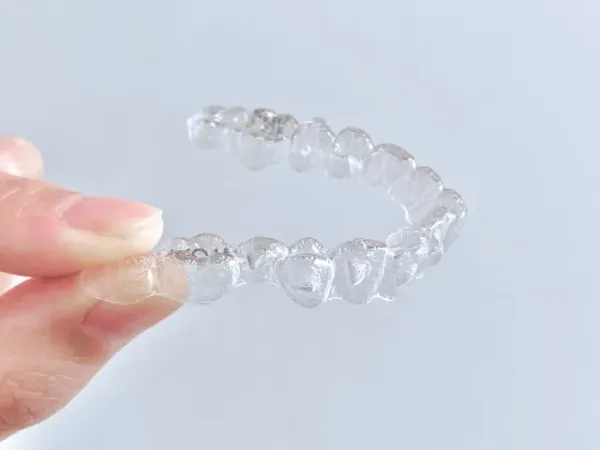 お食事や歯磨きの際に簡単に取り外すことができ、丸洗いや専用ケアで清潔に保てる透明なマウスピース型矯正装置
